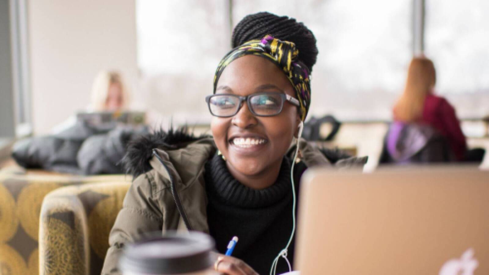 a GVSU adult student on her computer, studying in a coffee shop